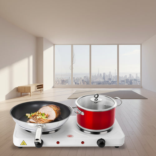Man cooking in a kitchen with a portable stove, pan, and pots.