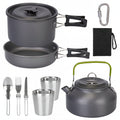 Camping cookware set with pots, pans, kettle, and utensils on a white background